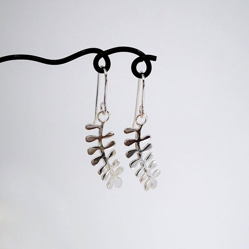 These light silver earrings are hand crafted in the shape of the NZ native Kowhai leaf. Made by Ruru Jewellery and available at Mason and Collins.
