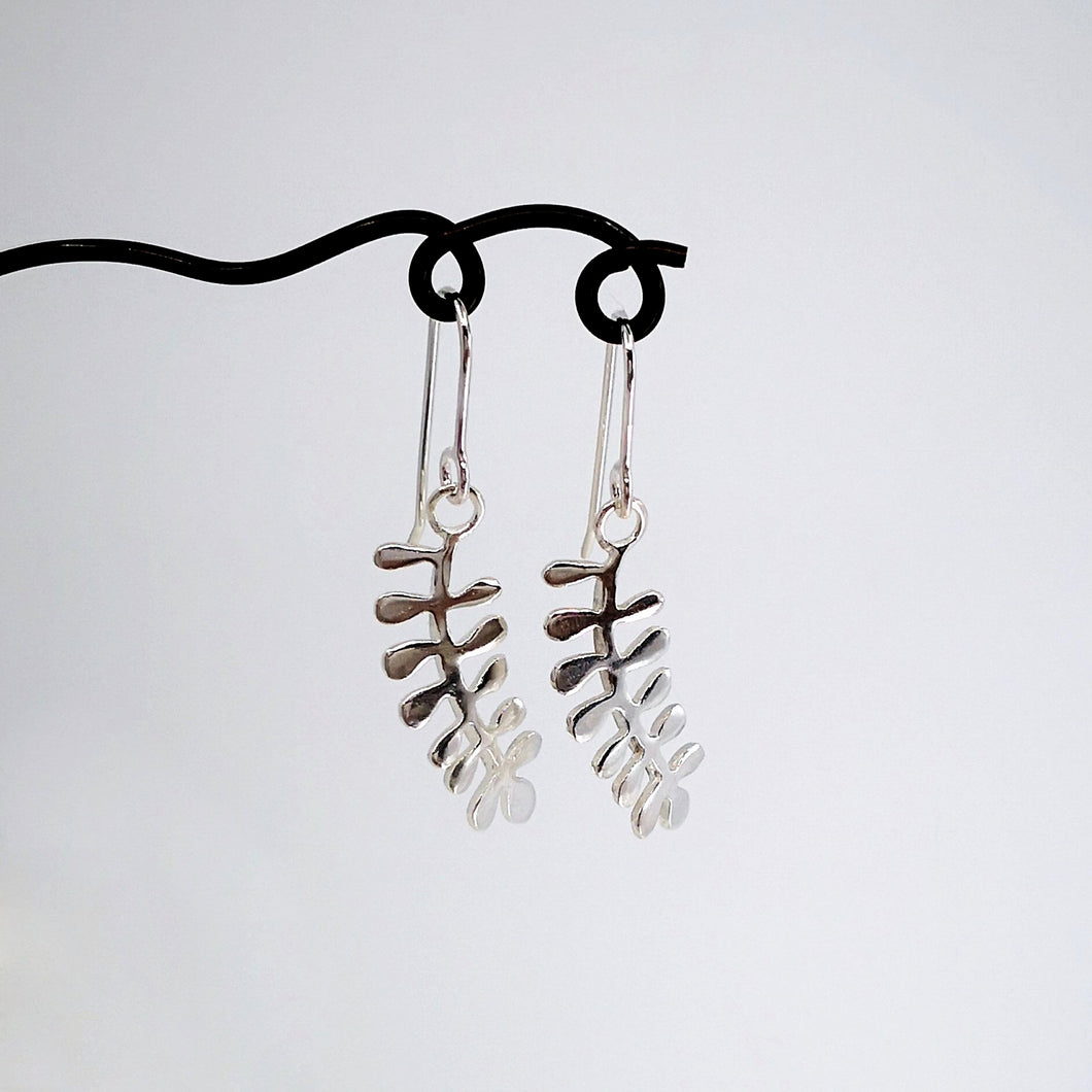 These light silver earrings are hand crafted in the shape of the NZ native Kowhai leaf. Made by Ruru Jewellery and available at Mason and Collins.